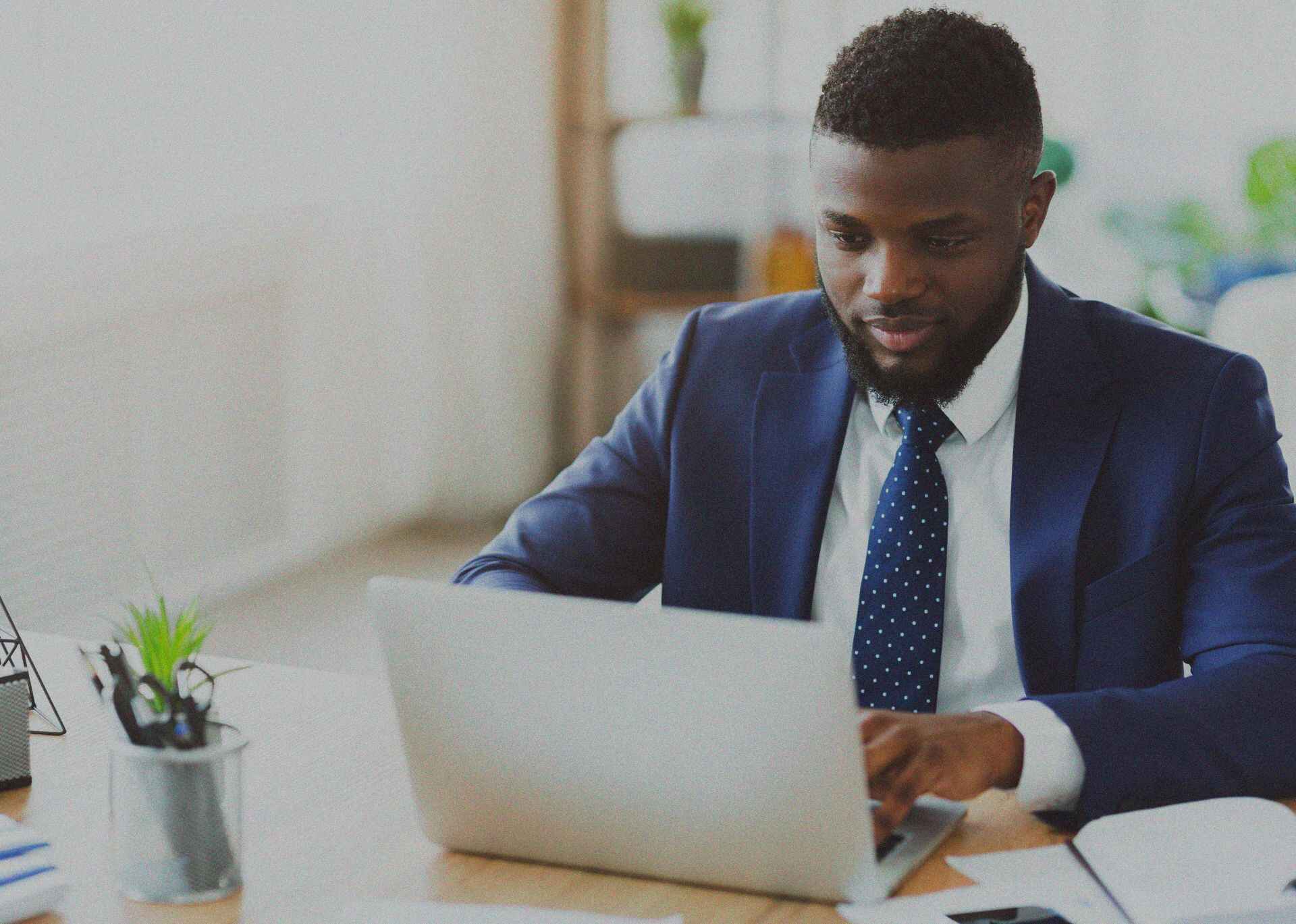 A man in a suit working on a laptop